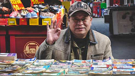 Händler verkauft Bücher auf chinesischem Markt (Foto Pixabay)