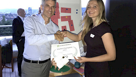 Fondstrends-Chefredaktor Christian Weber (l.) überreicht der glücklichen Gewinnerin Miranda Ademaj von Skenderbeg den Hauptgewinn.